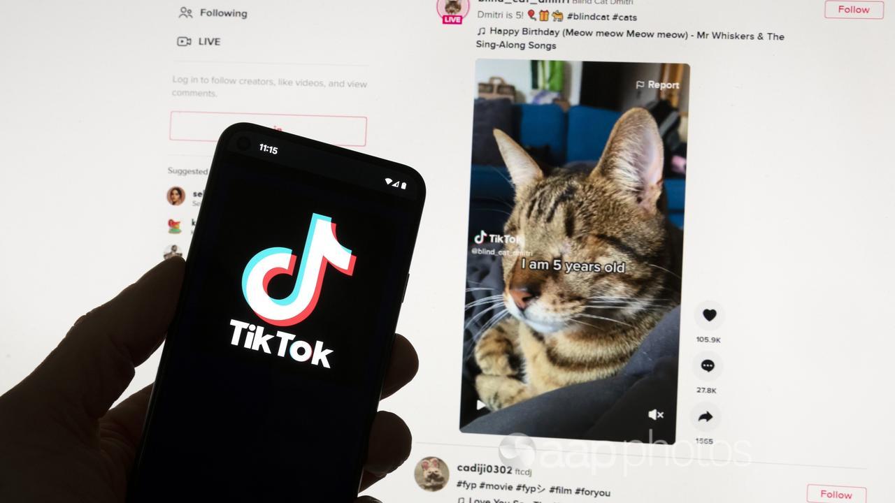 TikTok logo on a mobile phone in front of a computer screen.
