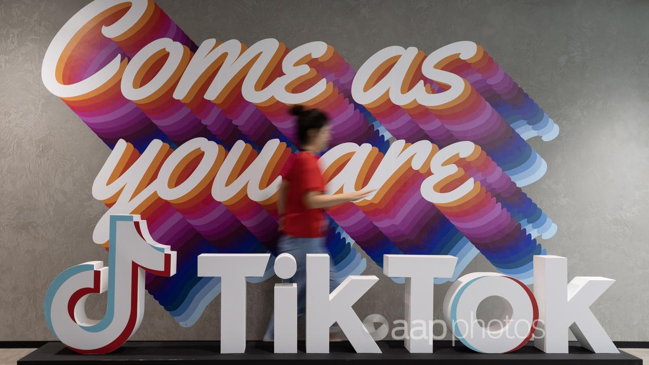 A worker walks past a TikTok sign in Singapore.