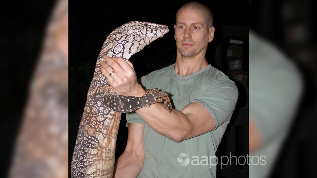 Professor Bryan Fry holds a perentie