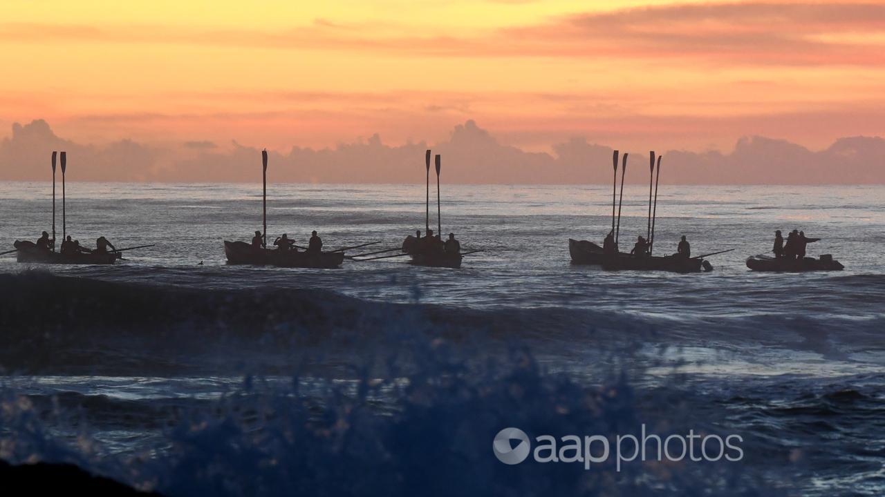 Surf boats perform a burial at sea during Anzac Day on the Gold Coast