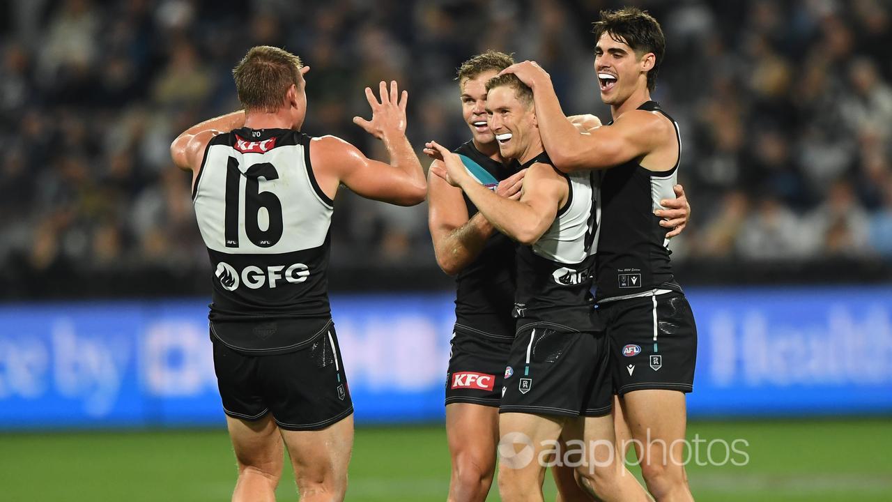 Port Adelaide players celebrate a goal.