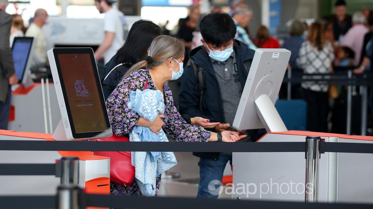Travellers check in at an airport.