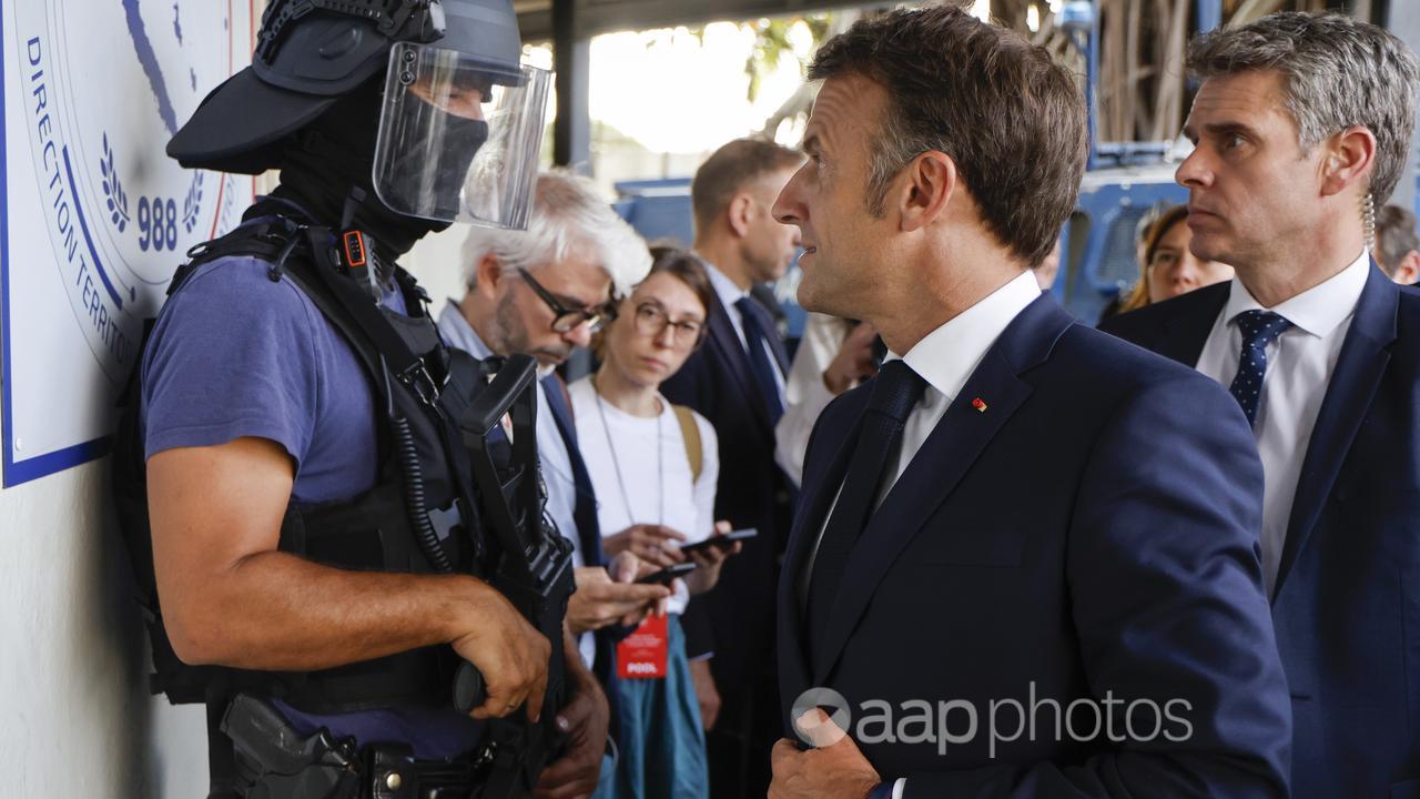 French President Emmanuel Macron arriving at Noumea police station