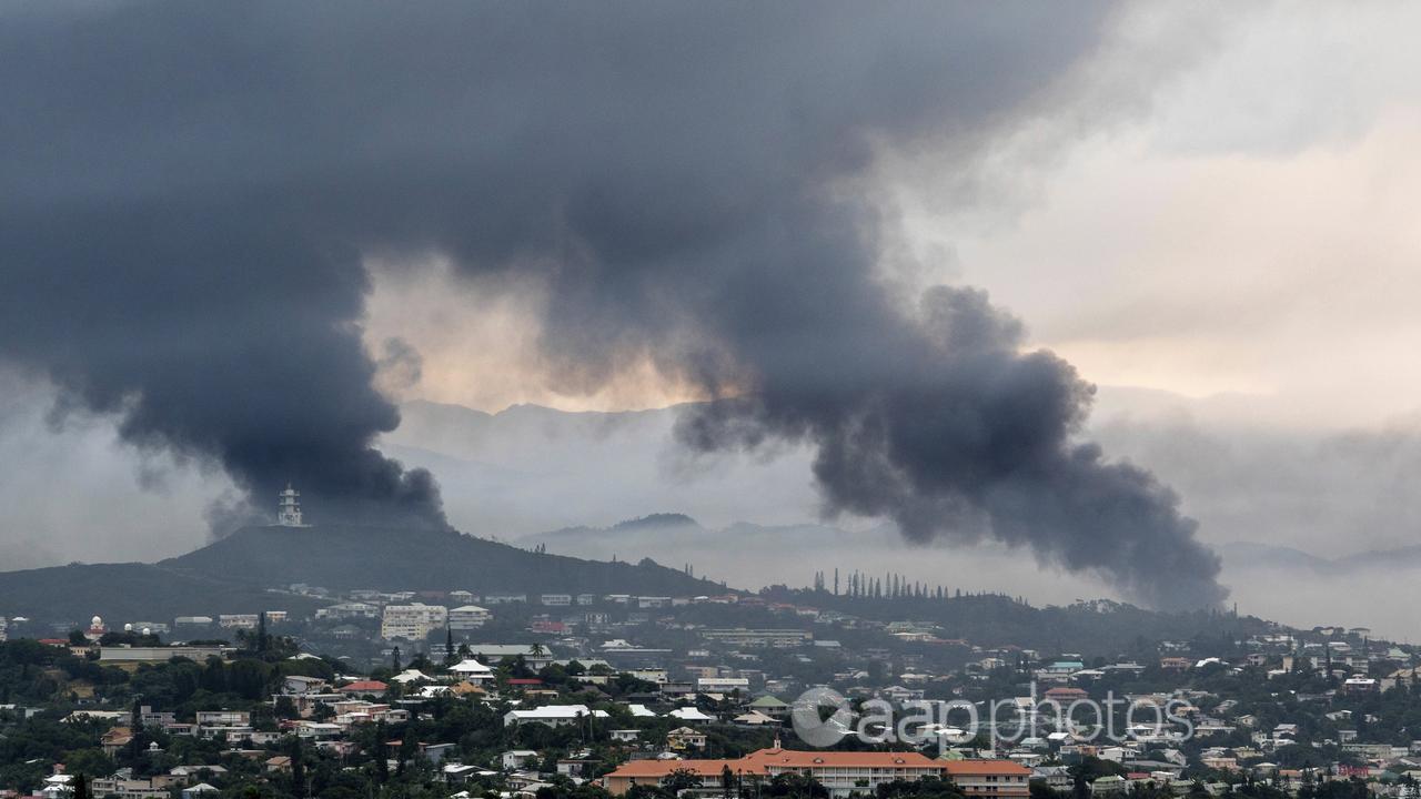 Smoke rises during protests in Noumea, New Caledonia.