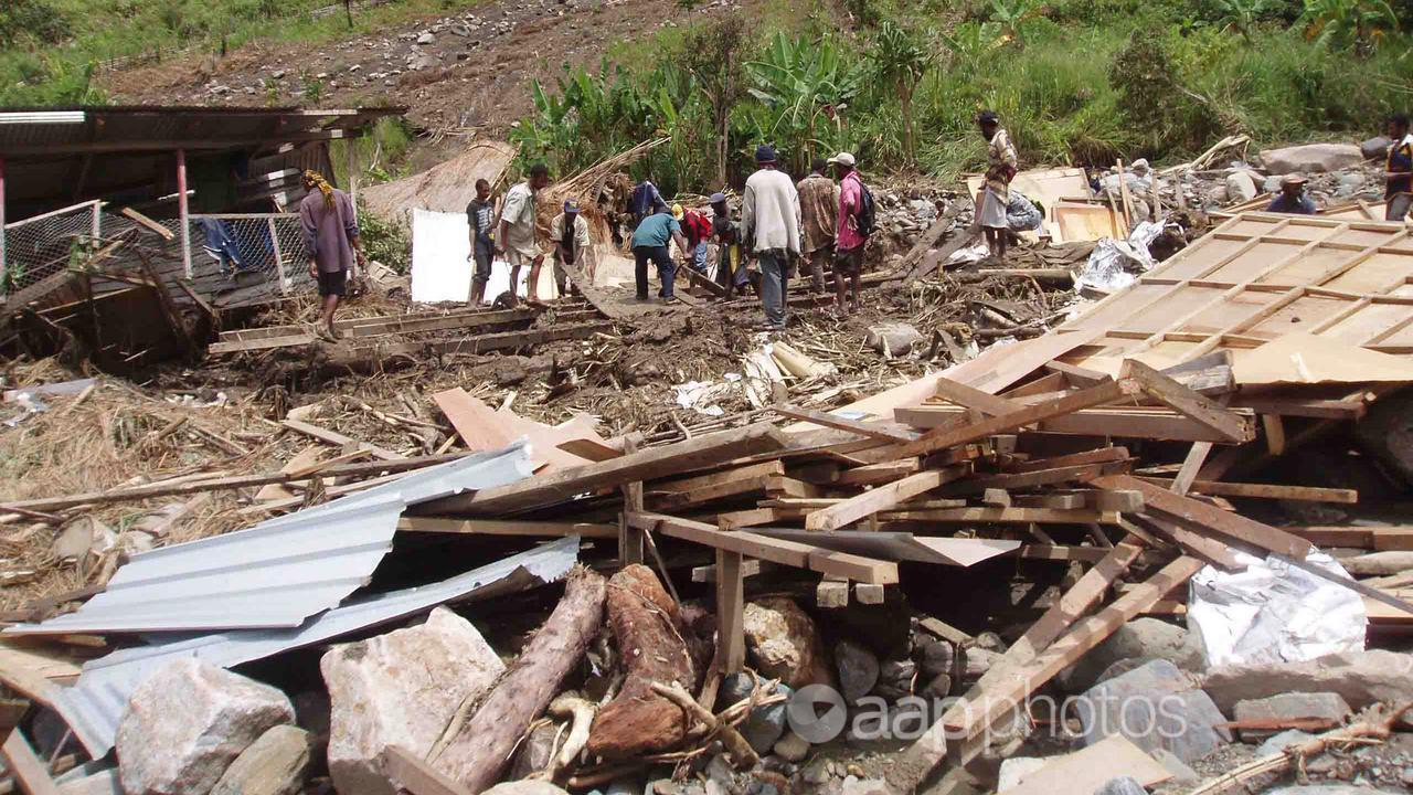 Villagers search for bodies in the debris of the PNG village of Bapa