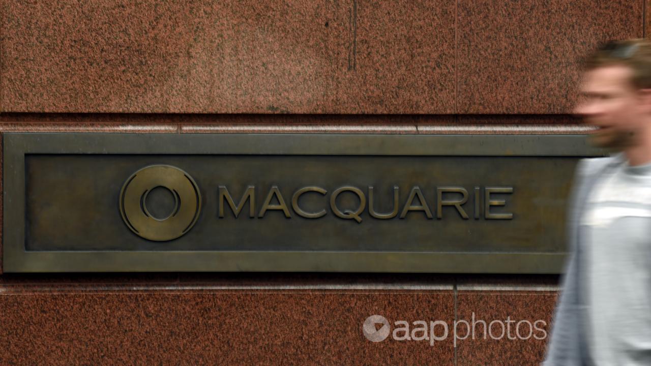 A pedestrian walks past the Macquarie Bank sign in Sydney