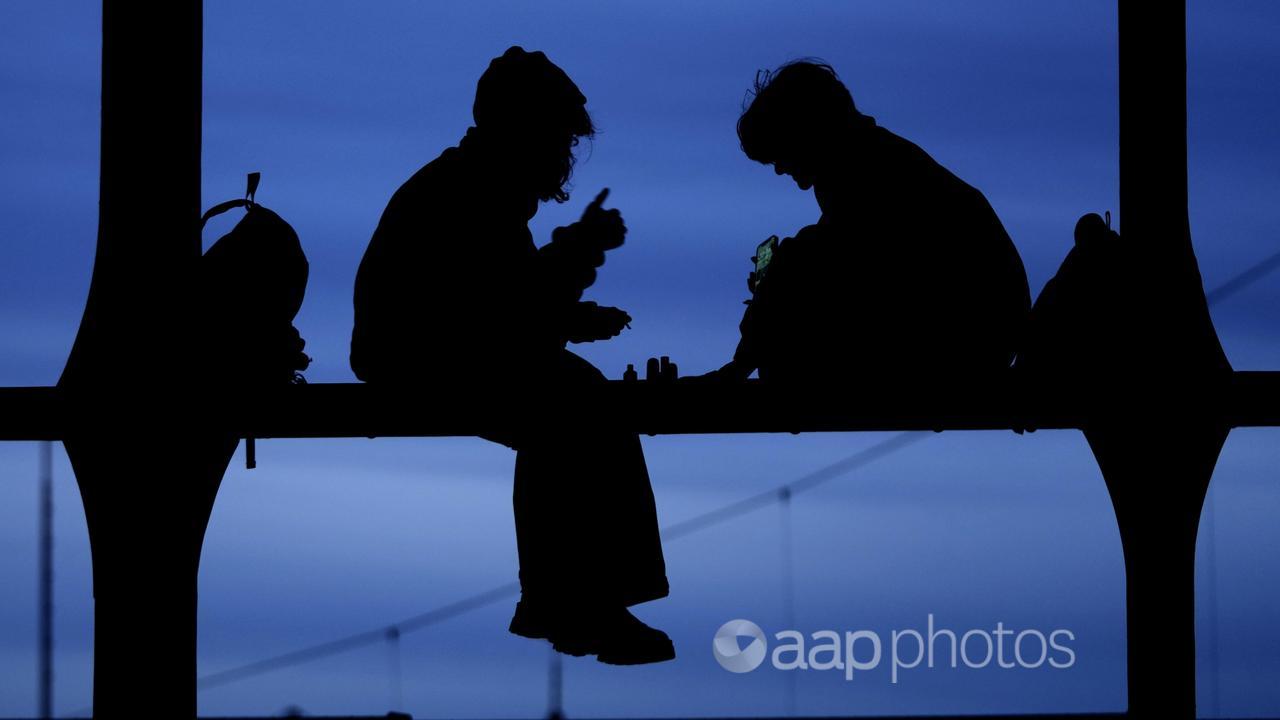 A photo of two children sitting on a bridge.