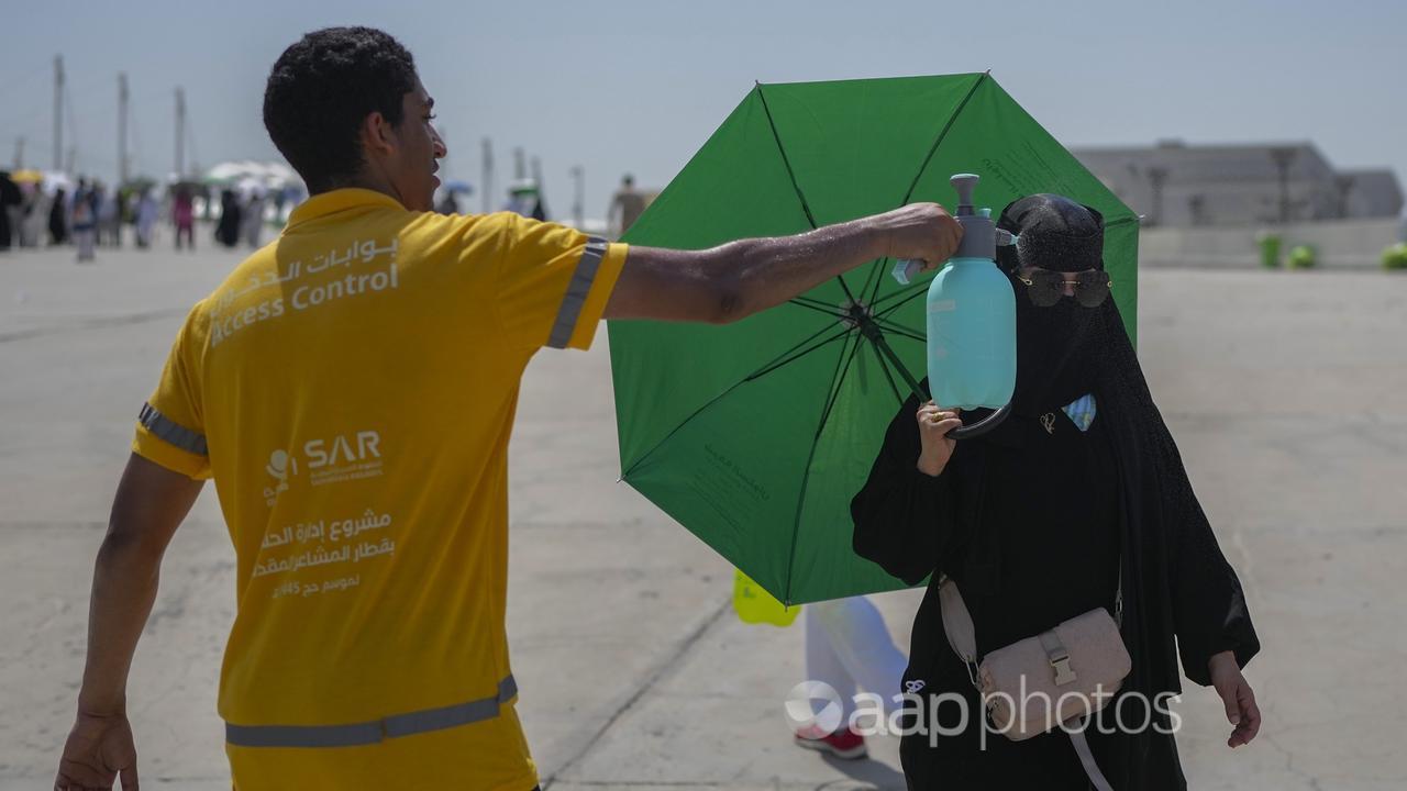 A pilgrim gets a cold water spray at the Hajj in Saudi Arabia.