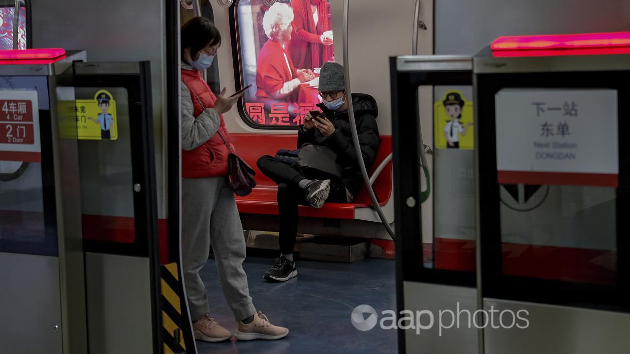 A picture of two commuters on a train in Beijing.