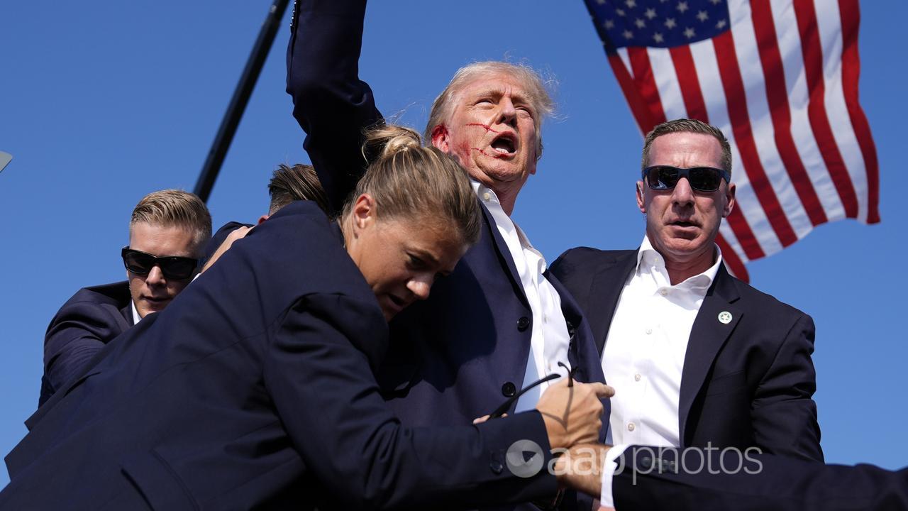 Donald Trump surrounded by US Secret Service agents after shooting