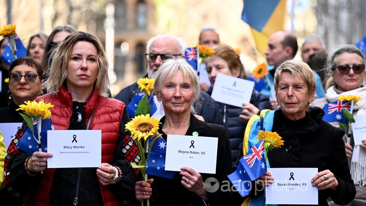 Attendees hold cards bearing the names of MH17 victims