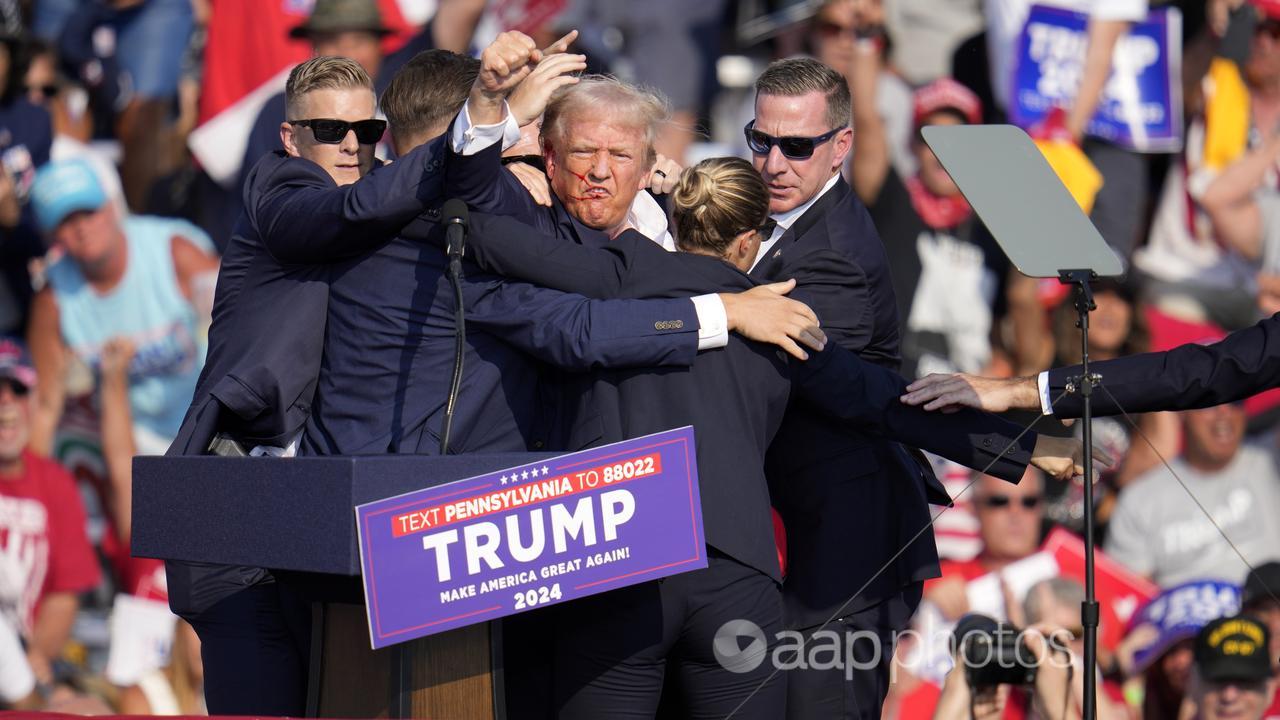 Donald Trump gestures to supporters after the shooting.