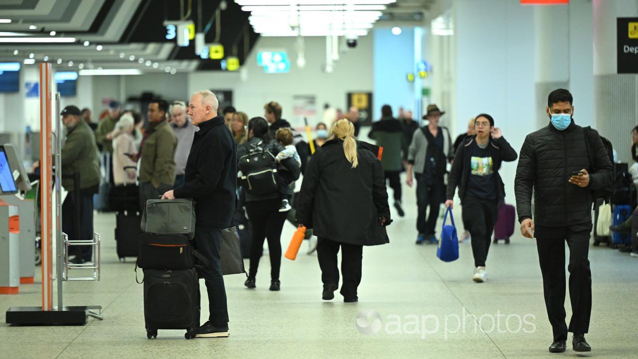 People walk through Melbourne Airport.