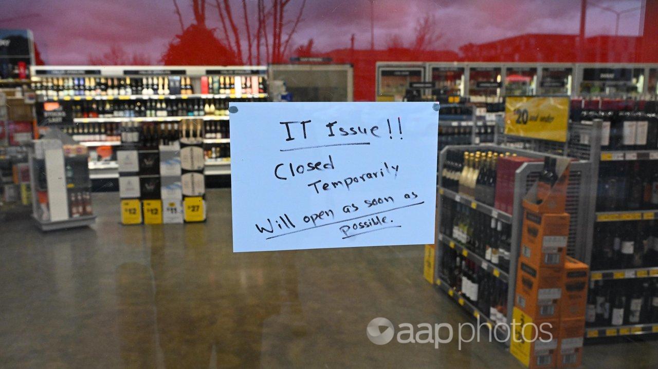 A sign notifies customers of a temporary closure due to IT issues