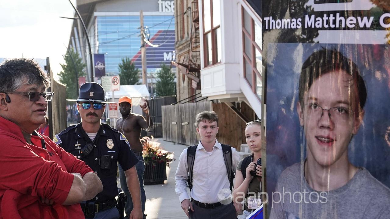 A man walks by a poster depicting Thomas Matthew Crooks