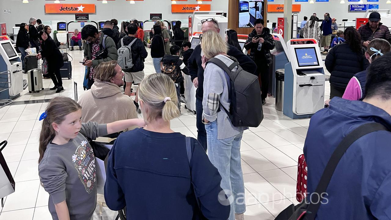 Jetstar passengers wait as check-in kiosks are closed