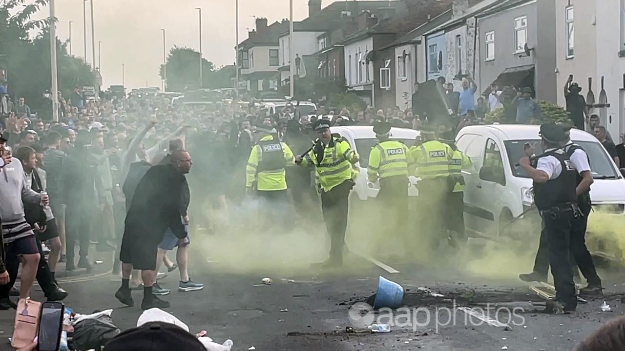 An unruly crowd clash with police in Southport, northwest England.