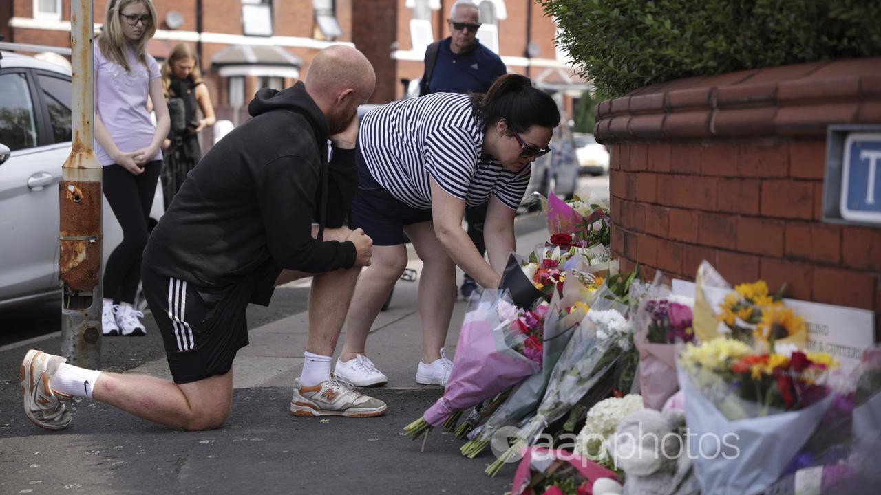 People leave flowers near where three children were killed in the UK.