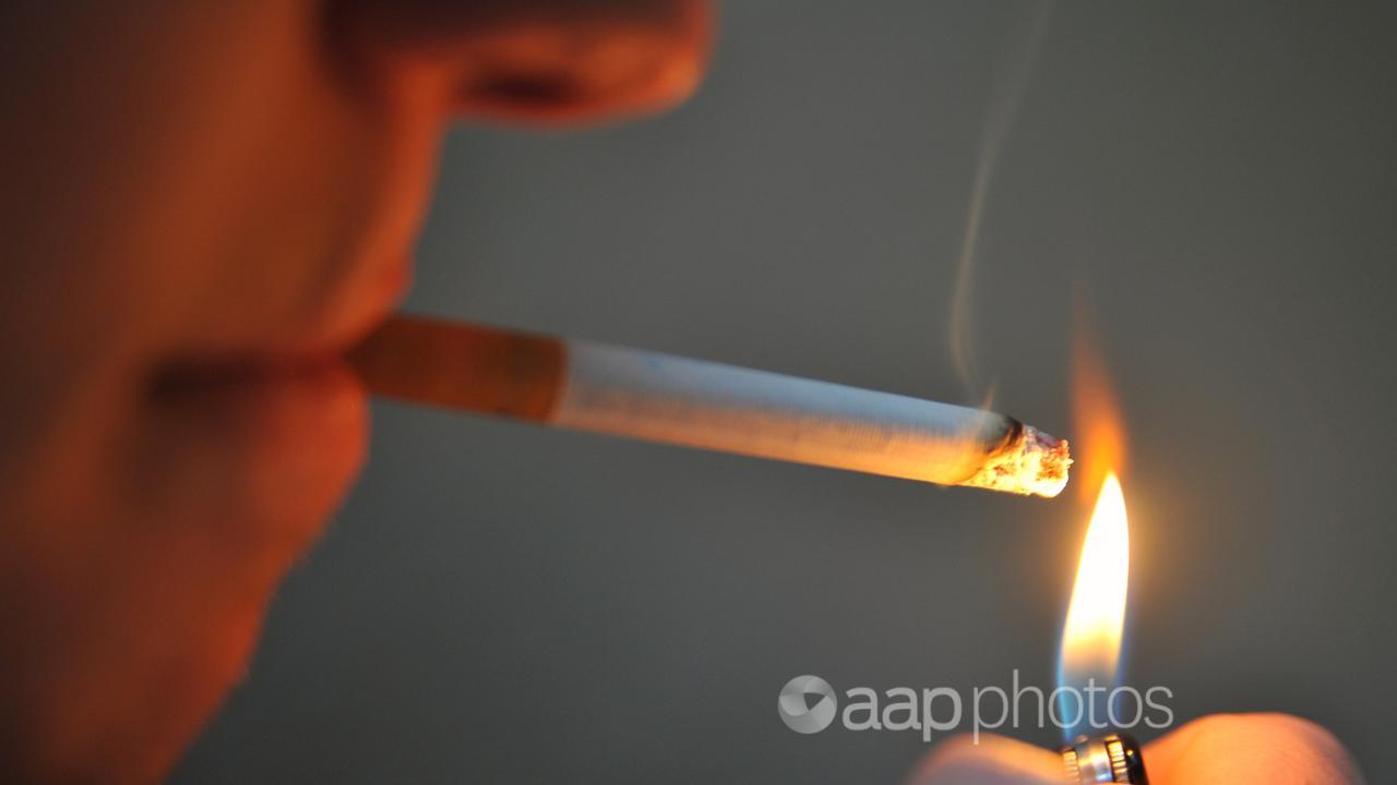 A man seen lighting a cigarette