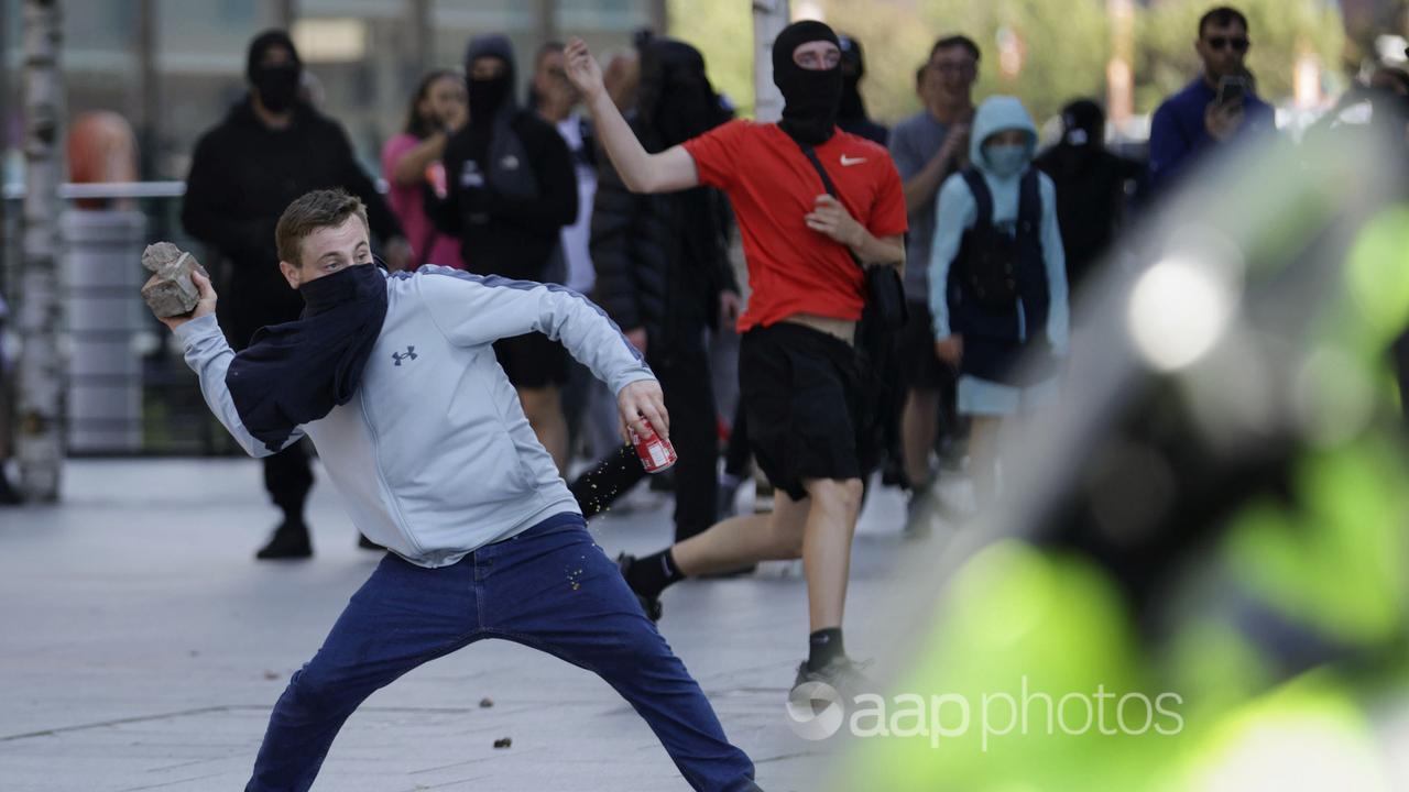 A demonstrator throws a brick during a protest in Liverpool, England