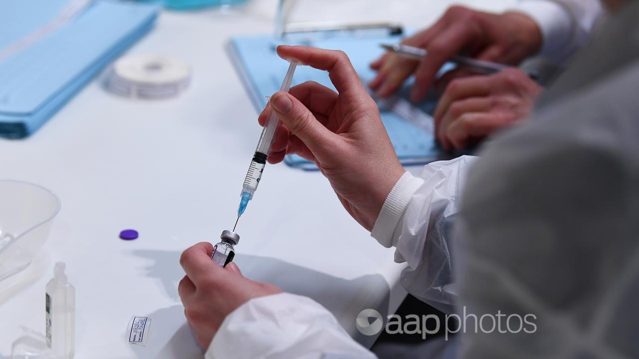 A healthcare worker preps a Covid19 vaccination dose