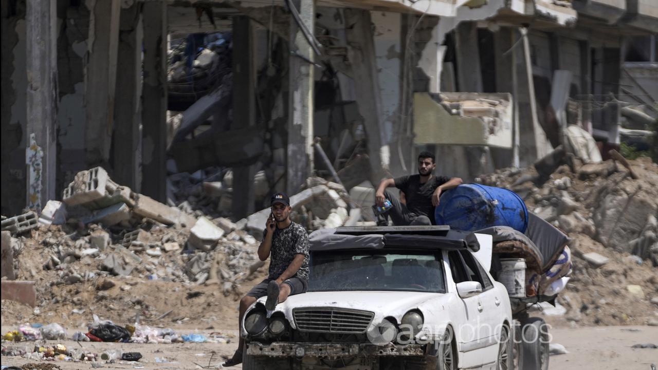 Two Palestinians transport their belongings out of the war zone.