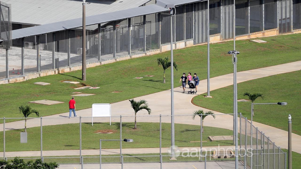 People walk in an immigration detention centre.