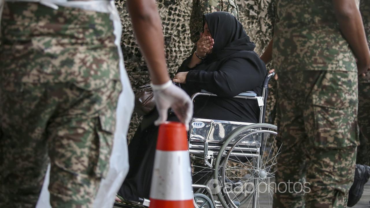 Malaysian army officers push a palestinian wheelchair patient 