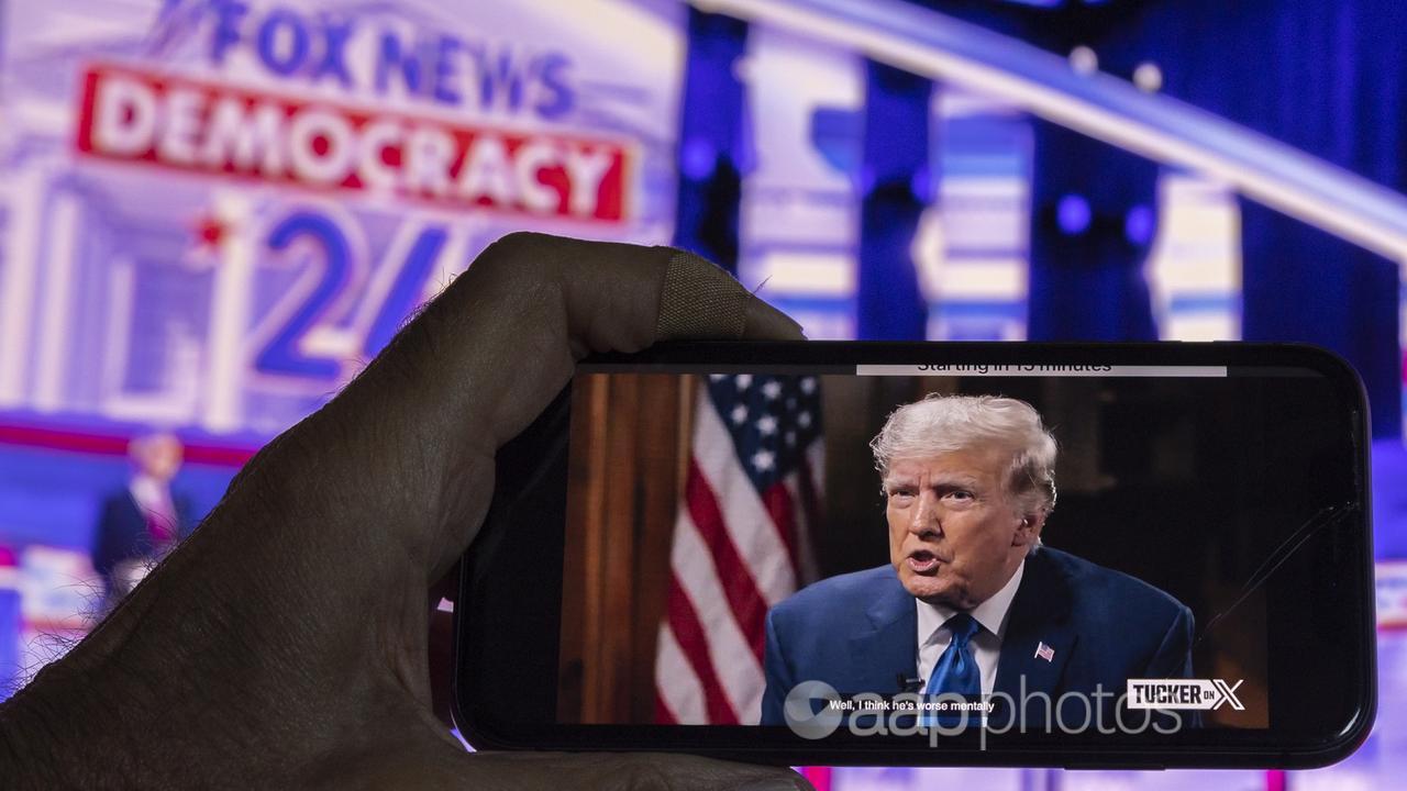 A viewer watches Trumps interview with Tucker Carlson on a phone