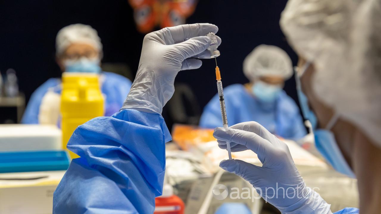 A health care worker fills a syringe (file image)