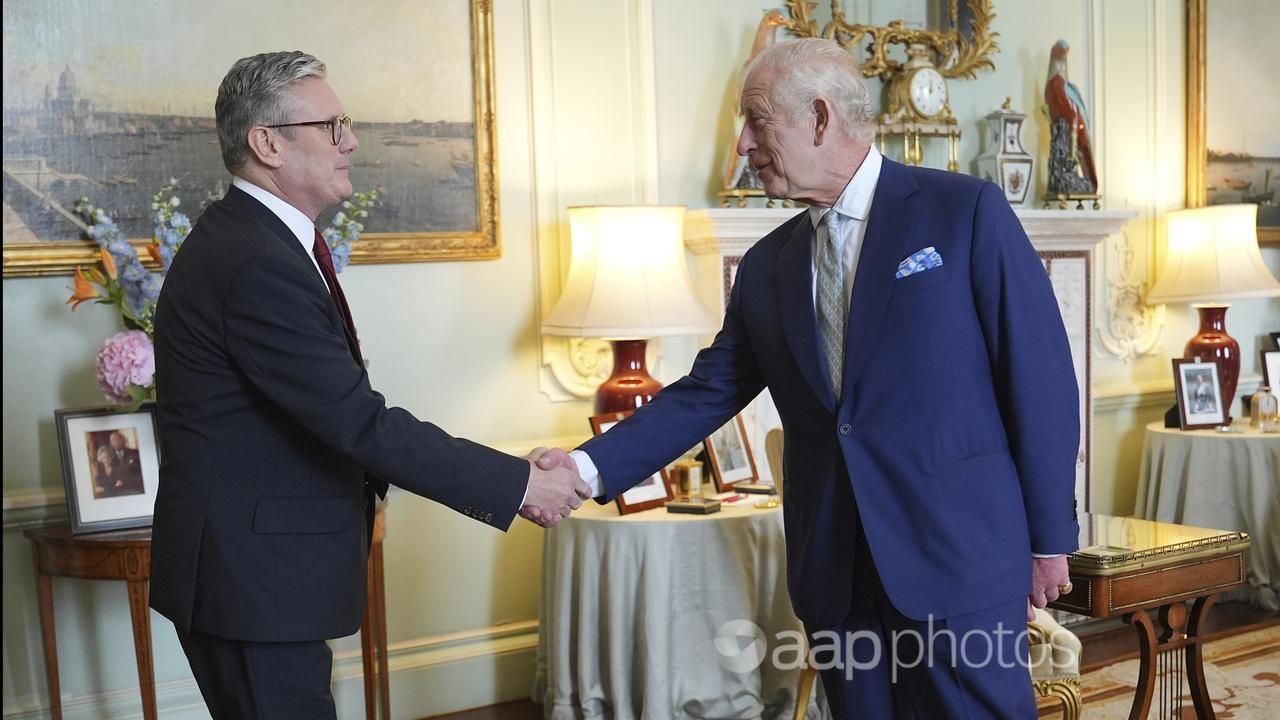 King Charles III shakes hands with Keir Starmer at Buckingham Palace