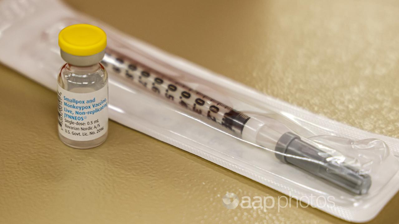 A vial containing the monkeypox vaccine and a syringe set on a table