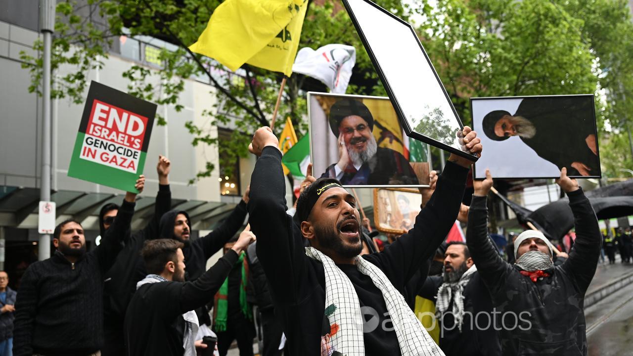 A protester in Melbourne with a photo of Hezbollah's Hassan Nasrallah