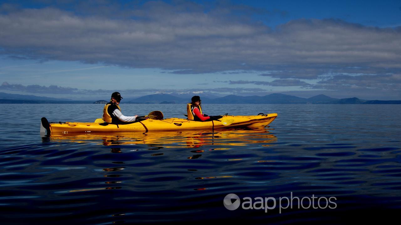 Visitors kayak on Lake Taupo in the North Island of New Zealand.