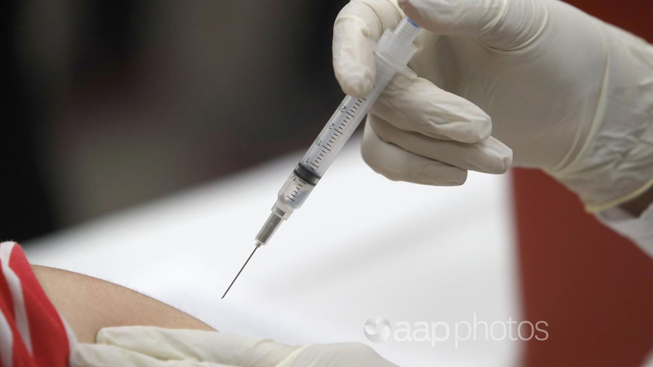 A vaccine being administered via an injection.