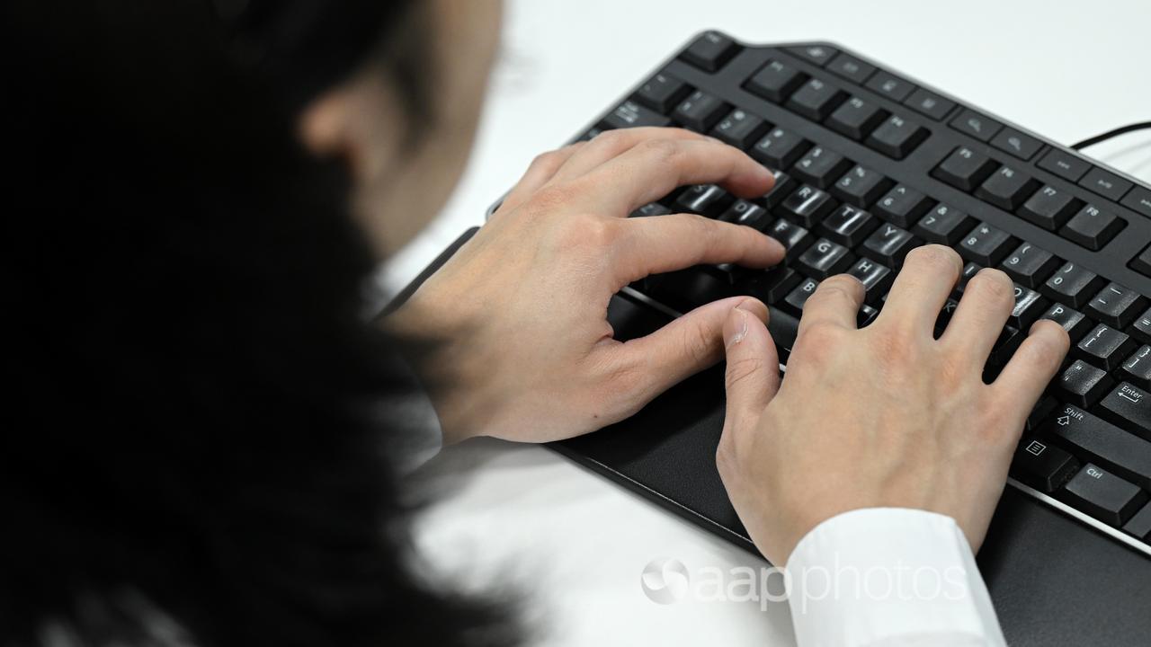 Stock image of a person typing on a keyboard.