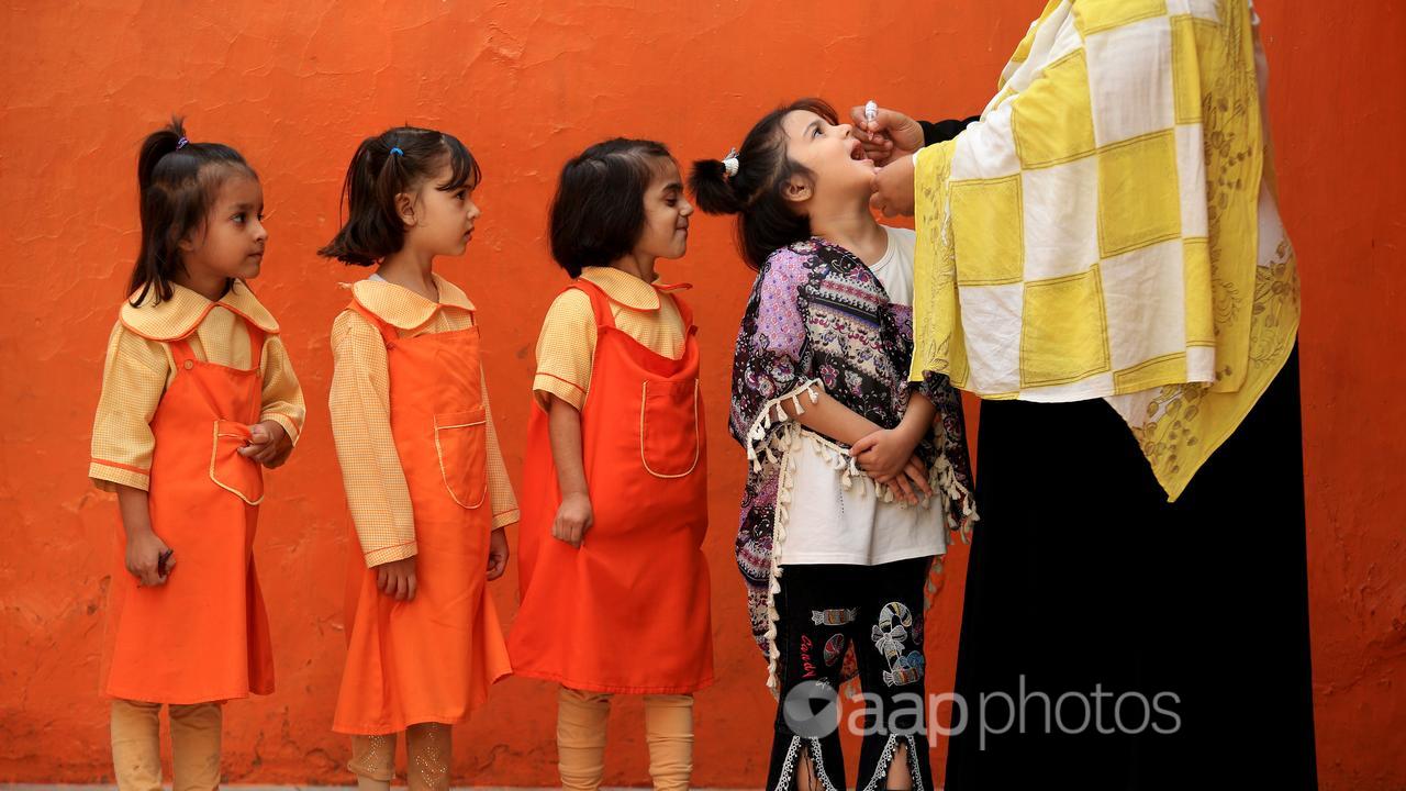 Children receive polio vaccine in Pakistan.