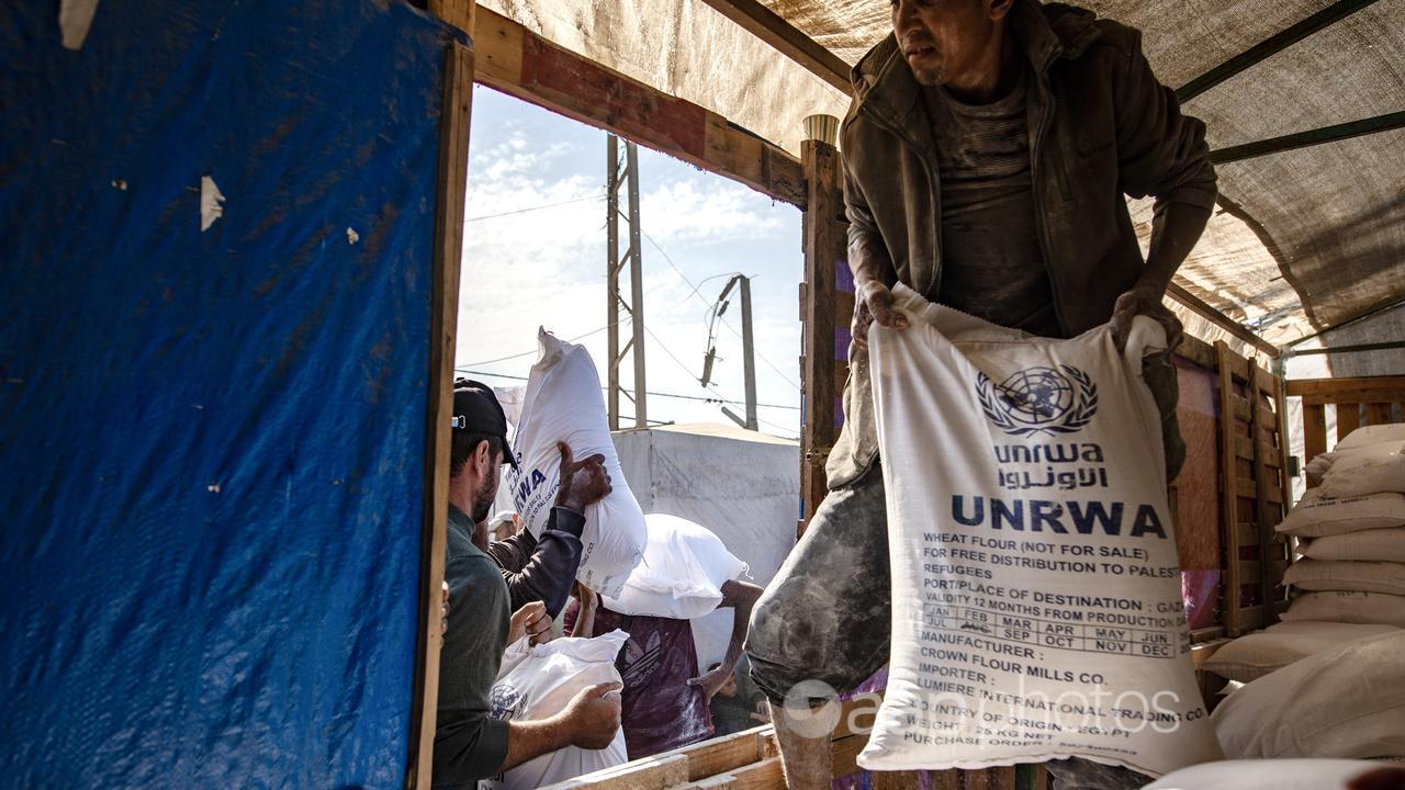 UNWRA workers distribute bags of flour to Palestinians