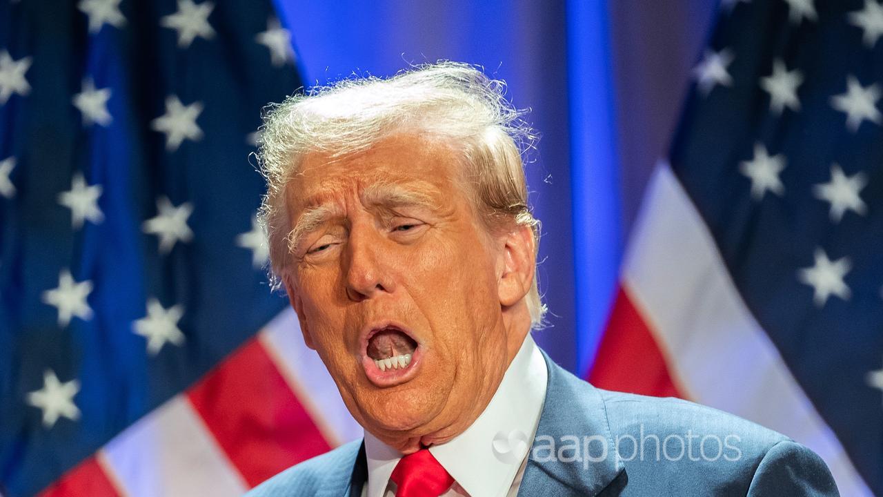 Donald Trump in front of US flags