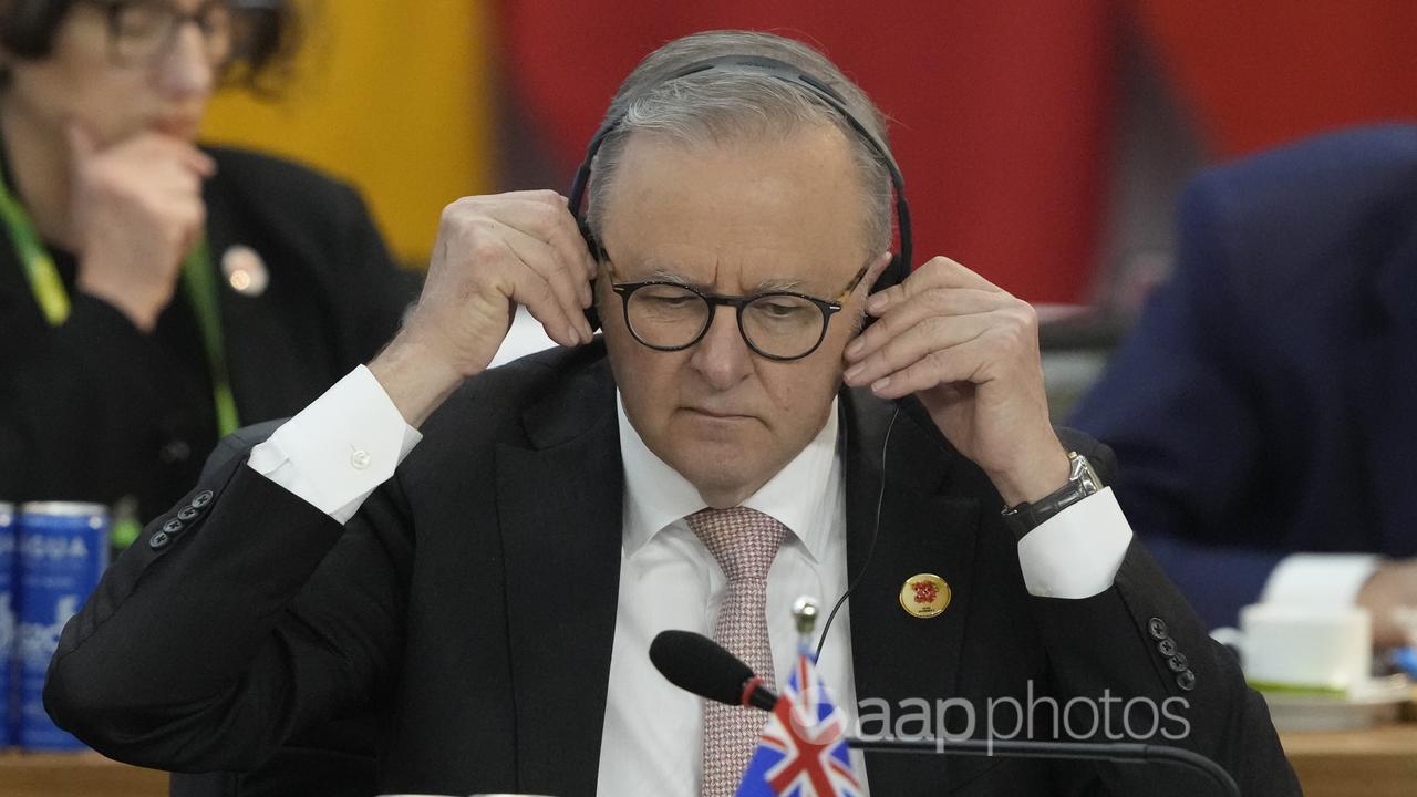 Prime Minister Anthony Albanese adjusts his headphones