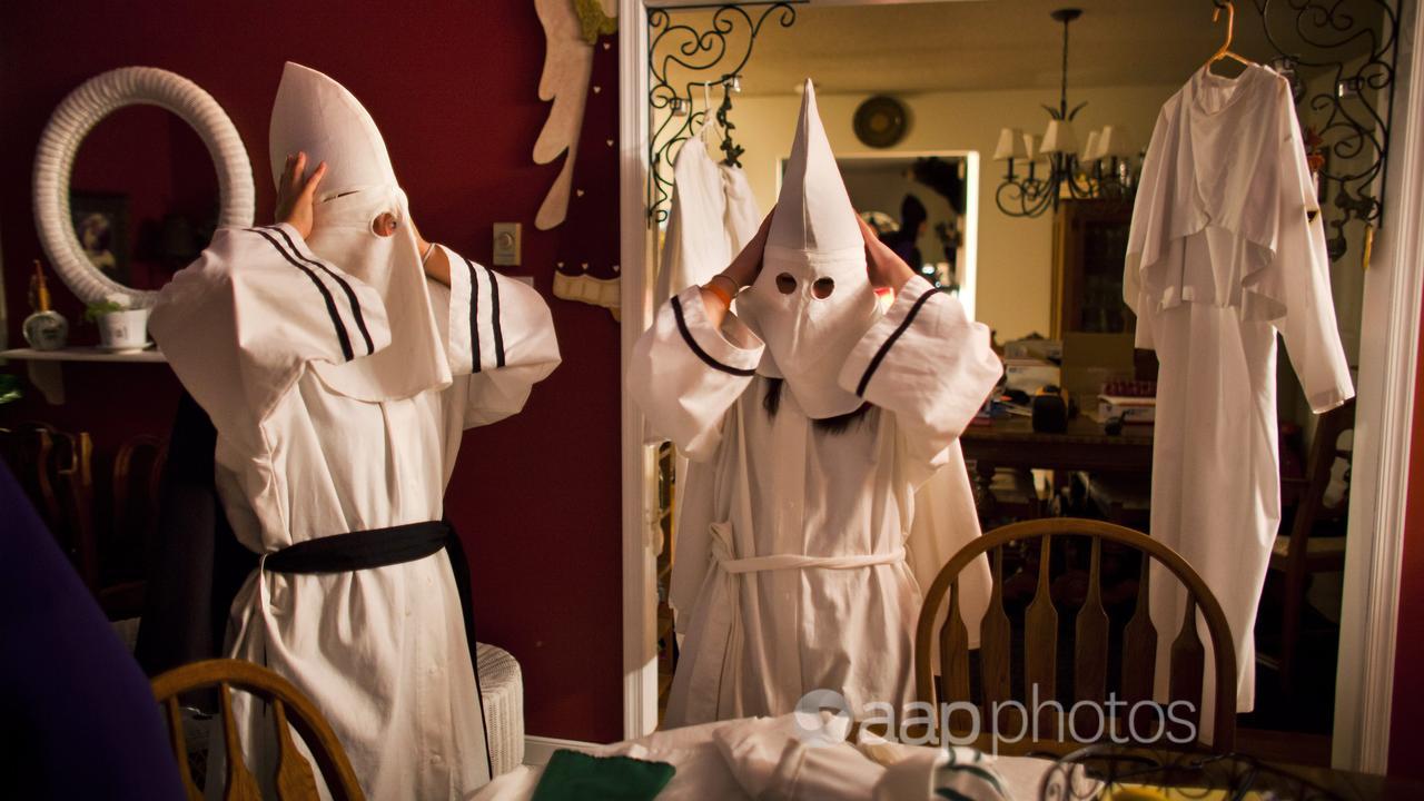 Two Ku Klux Klan members donned robes and hoods.