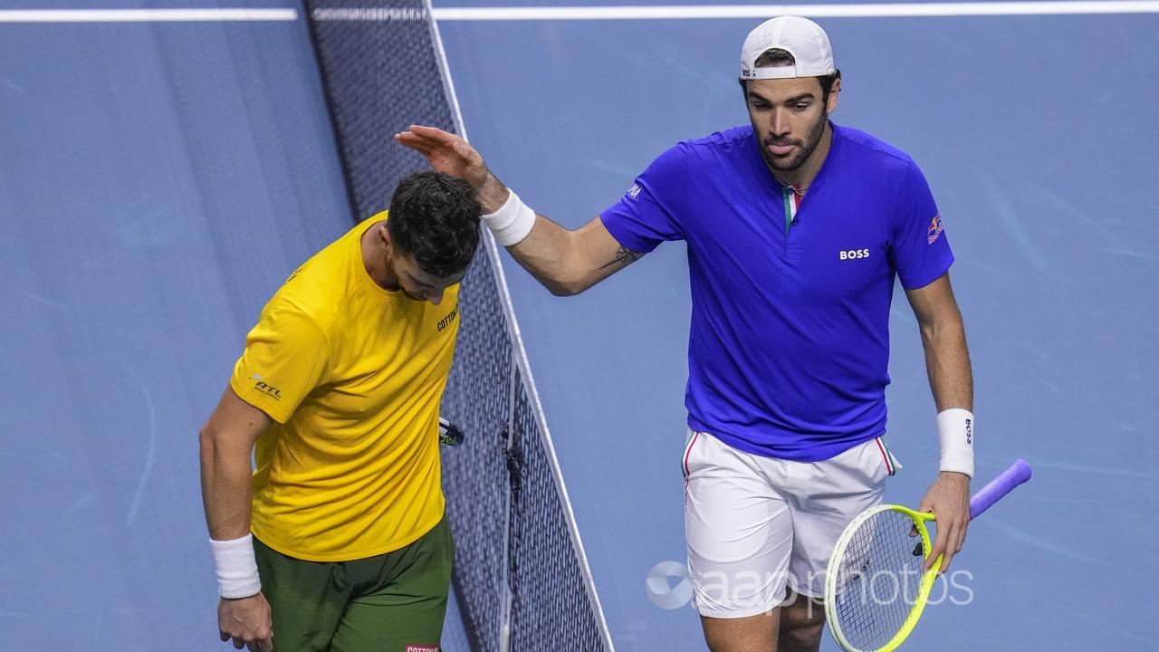 Italy's Matteo Berrettini (r) comforts Australia's Thanasi Kokkinakis.