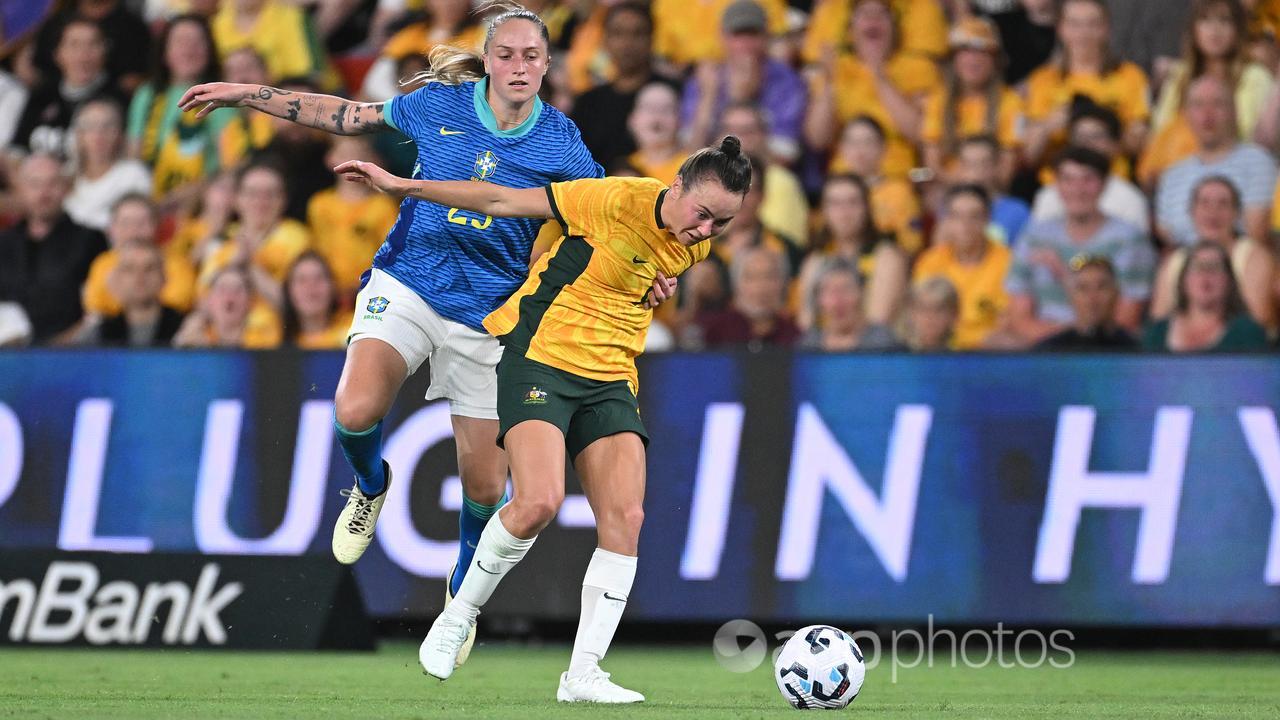 Isadora Haas Gehlen of Brazil holds Matildas star Caitlin Foord.