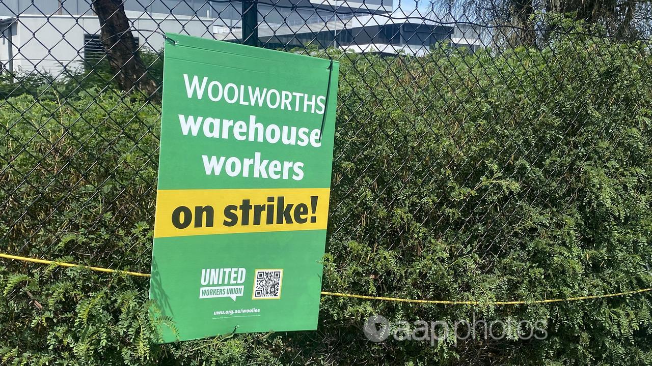 A placard on a fence at a Woolworths warehouse