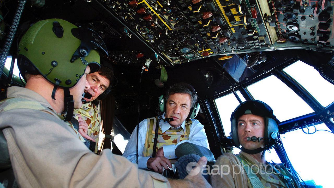 Defence Minister Robert Hill with pilots in Hercules aircraft cockpit