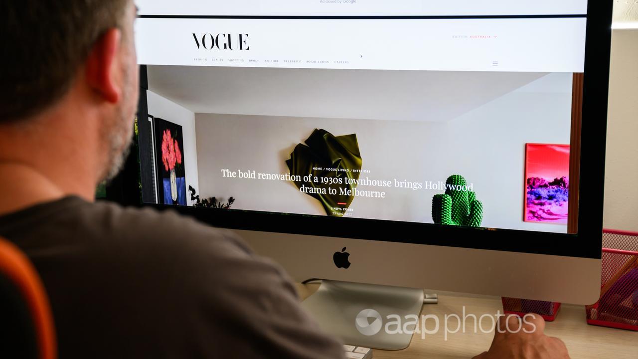 Man views online Vogue article on a computer.