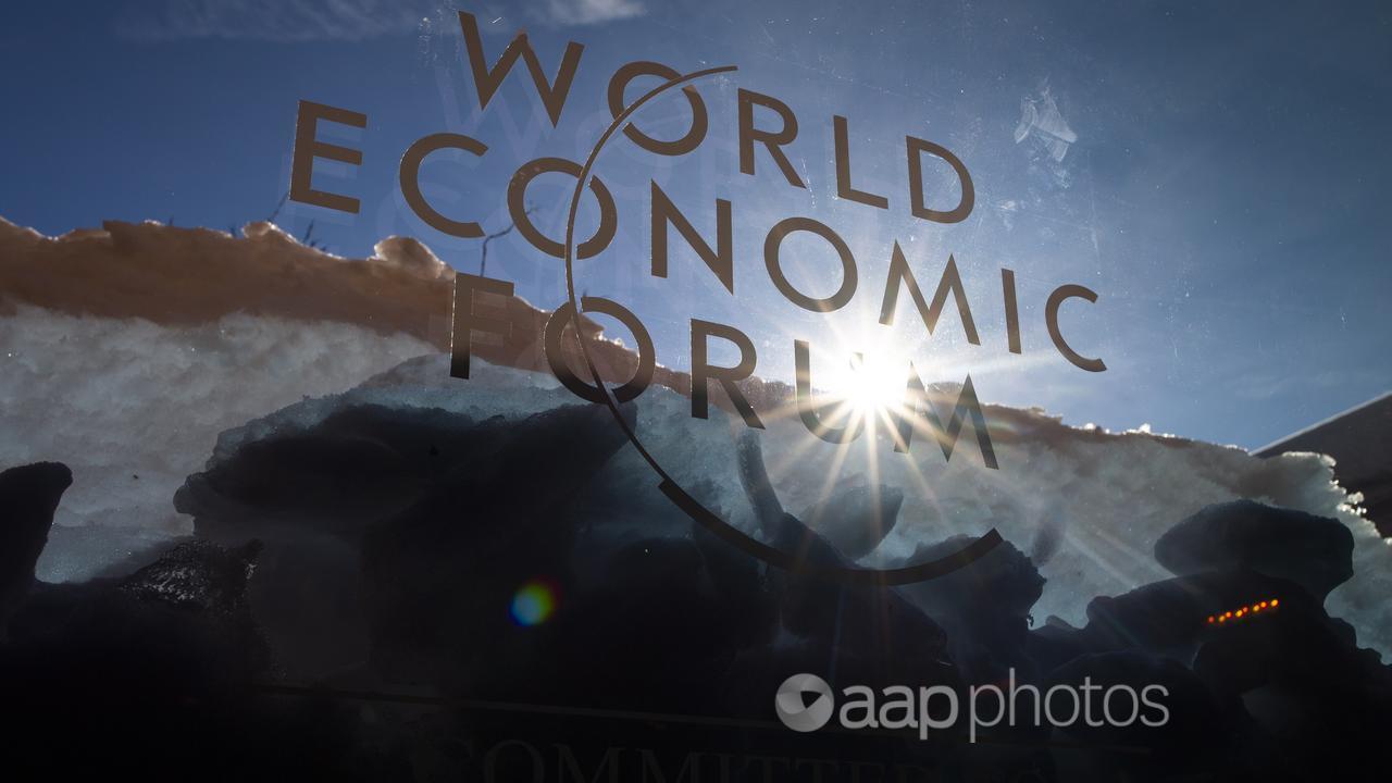 Sun shines through the logo of the  World Economic Forum, Davos