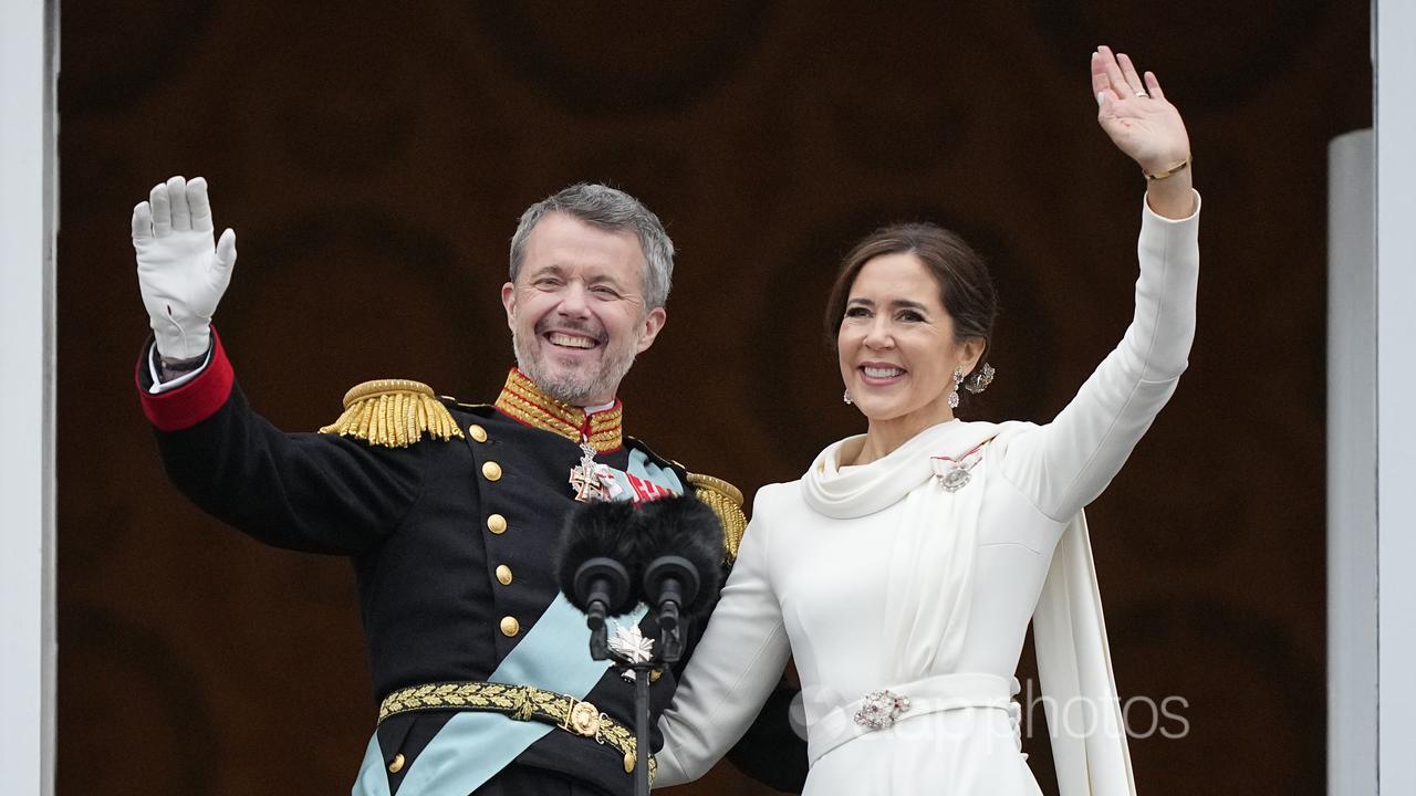 King Frederik and Queen Mary wave from a balcony