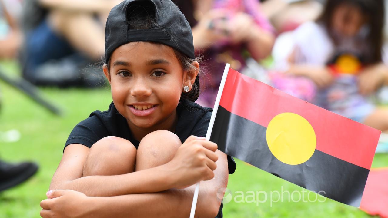 A child with an Aboriginal flag at an Invasion Day rally in Brisbane.